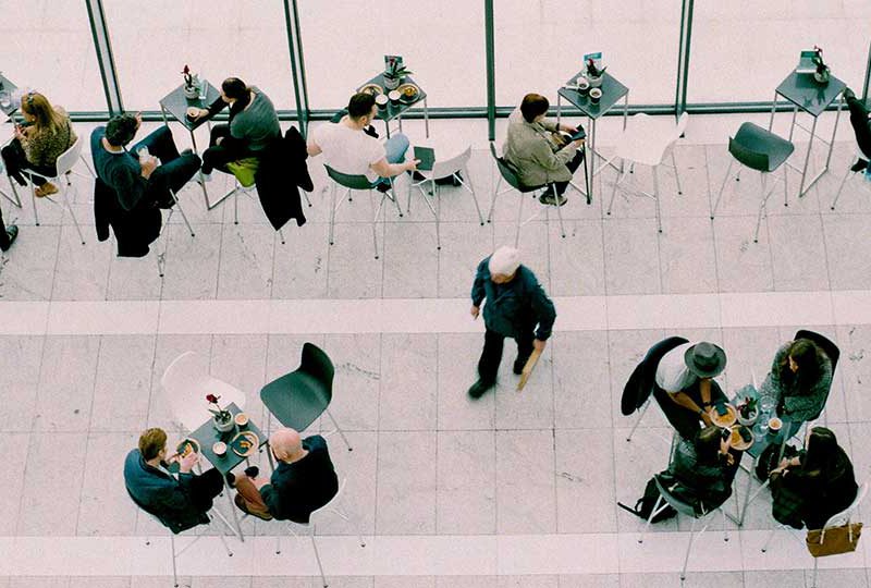 Overhead shot of people sitting at tables at a cafe.