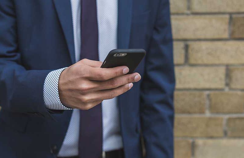 Man in suit holding cell phone
